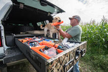 A man with his dog getting his training gear ready in a TruckVault.