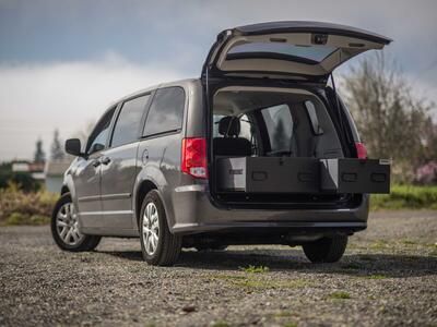 A black Grand Caravan with the trunk open and a magnum height TruckVault inside.