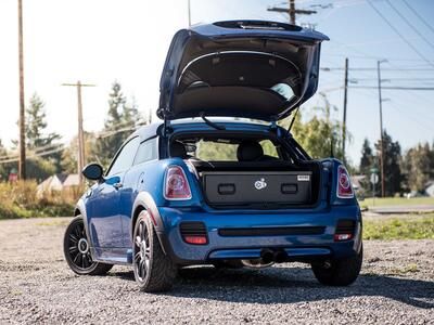 A blue Mini Cooper with an elevated TruckVault in the cargo space.