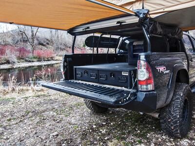 A Toyota Tundra with a TruckVault secure storage system in the bed and a rooftop tent 