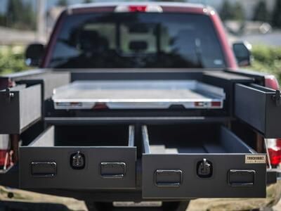A red Ford F250 with a custom All-Weather TruckVault in the truck bed and a CargoGlide on top.