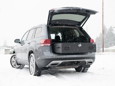 A Volkswagen Atlas parked in the snow with an open TruckVault in the rear.