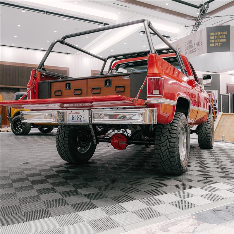 Red 1985 Chevy K10 with tailgate open showing a Magnum TruckVault with teak drawer faces