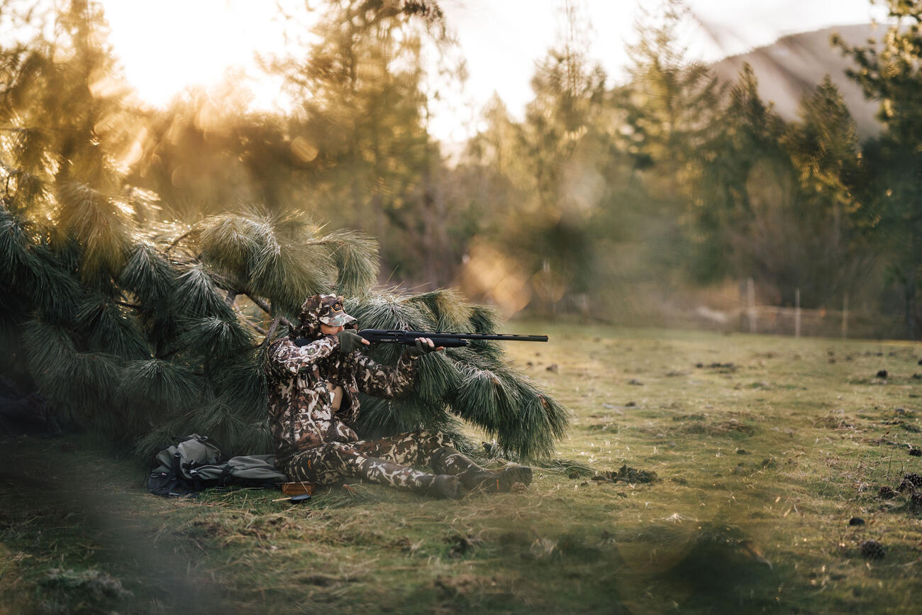 hunter hiding in low lying branches