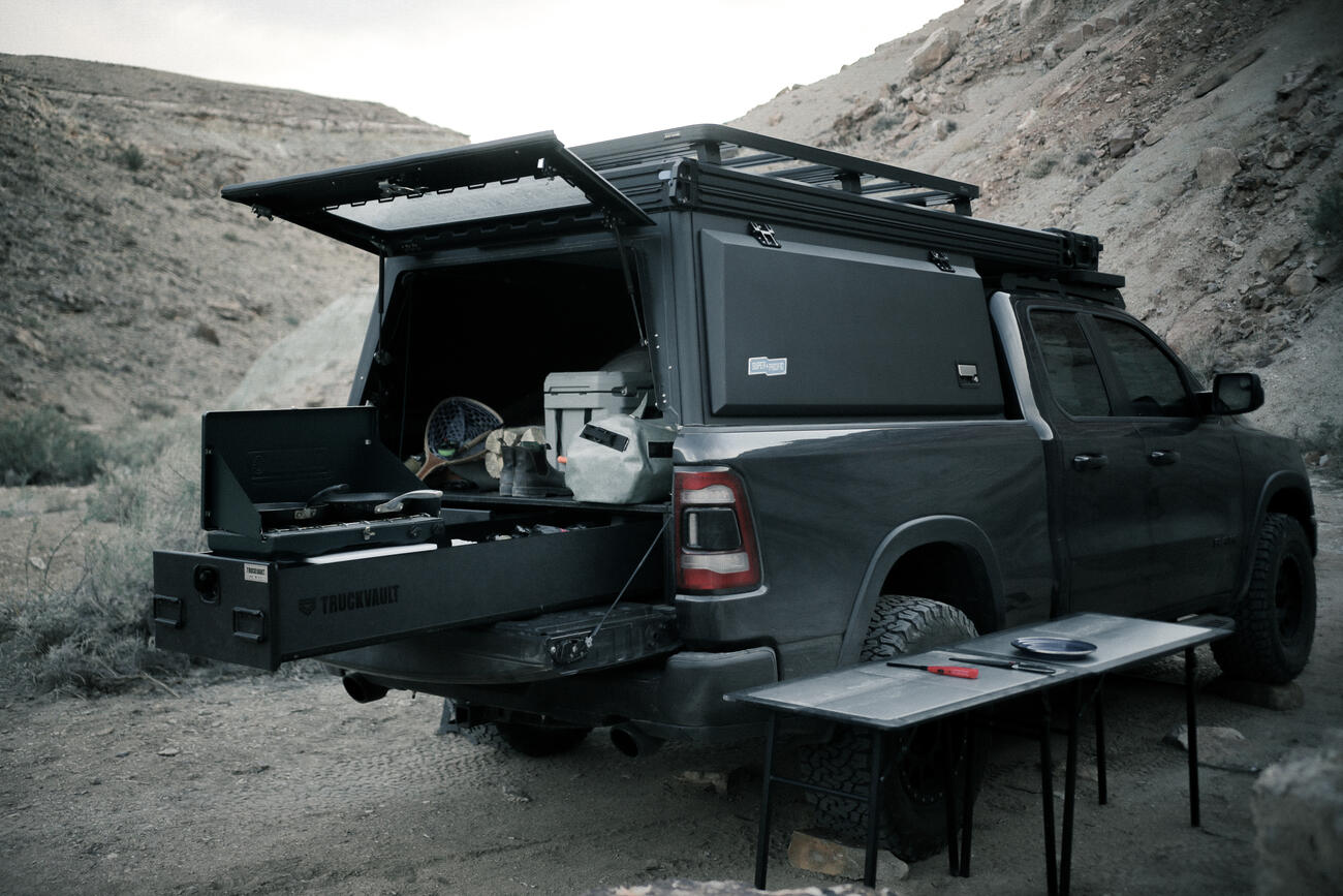 covered pickup truck with TruckVault secure storage drawer extended with fishing gear and camp kitchen inside