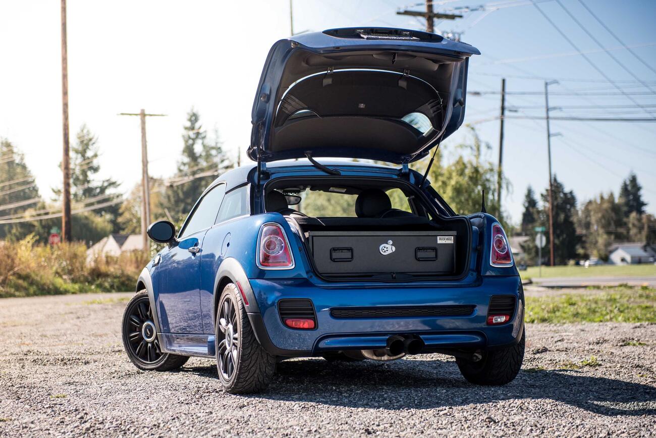 A blue Mini Cooper with an elevated TruckVault in the cargo space.