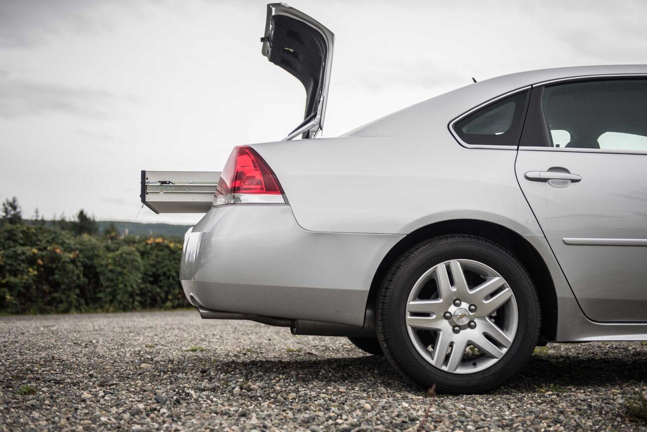 A silver Chevy Impala with an opened TruckVault in the trunk.