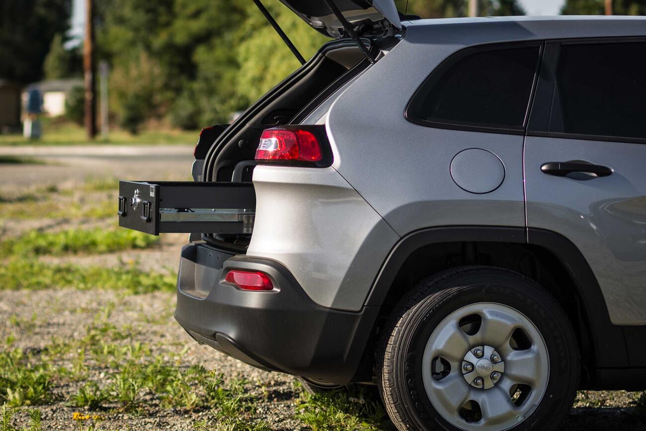 Law Enforcement A Jeep Grand Cherokee parked with a TruckVault opening out of the rear.