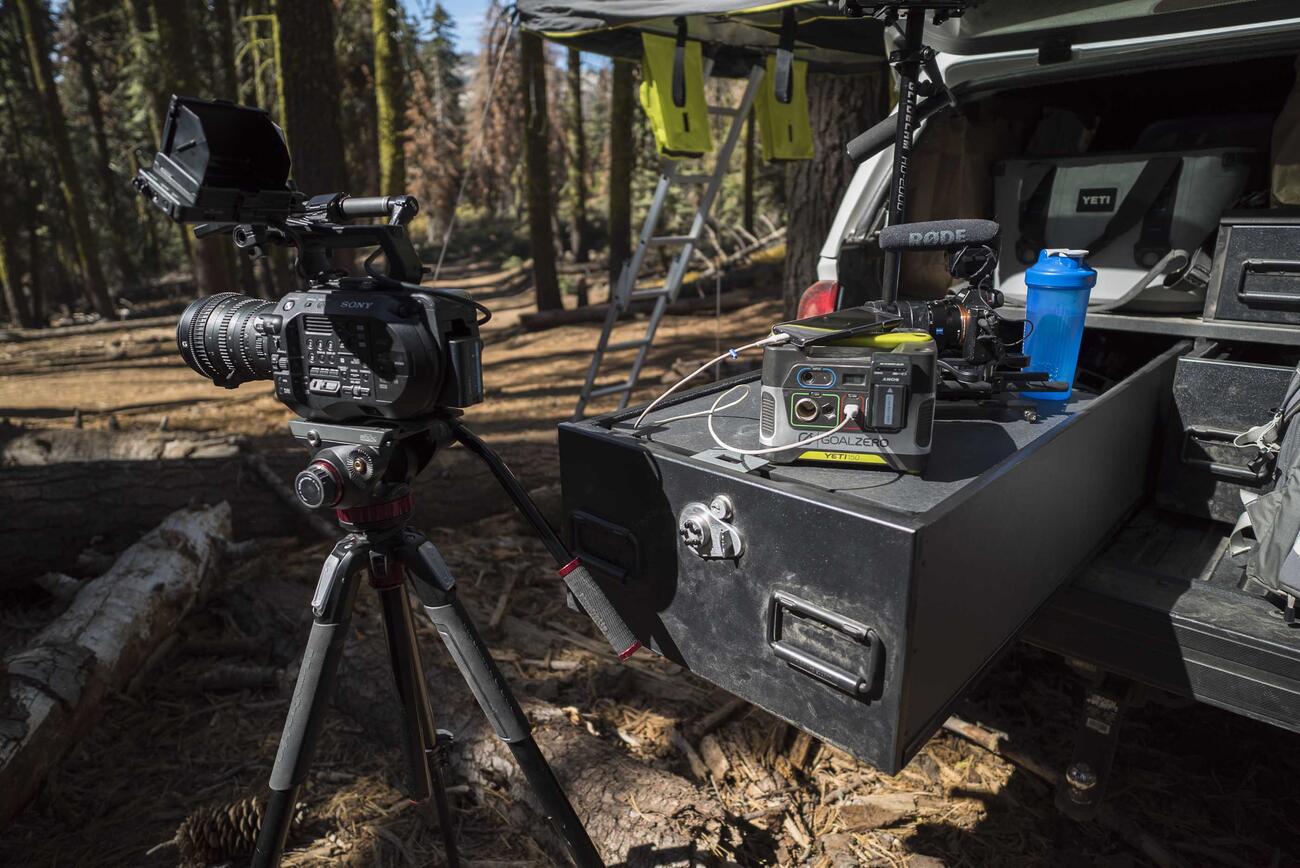 A TruckVault with a camera on a tripod placed on the ground next to the TruckVault.