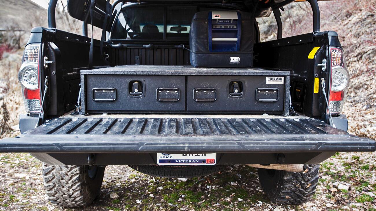 A Toyota Tacoma with a TruckVault secure storage system in the bed.