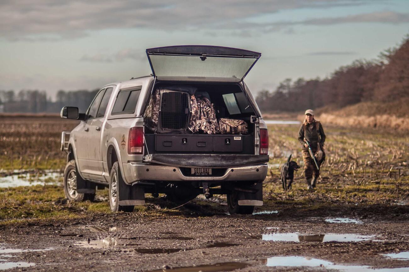 A Ford F-150 with with a Magnum 2 Drawer All-Weather TruckVault storage system in it, sitting in a muddy field.