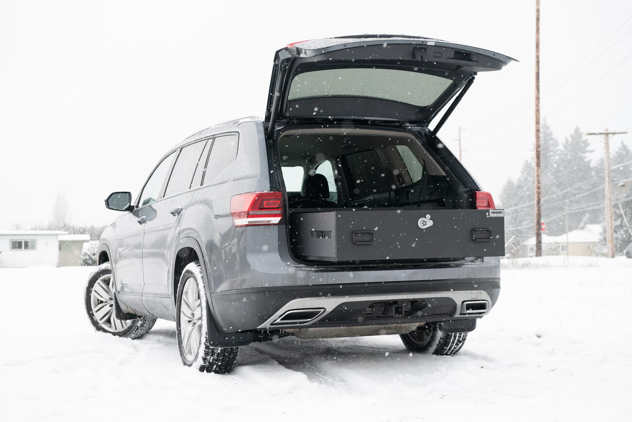 A Volkswagen Atlas parked in the snow with an open TruckVault in the rear.