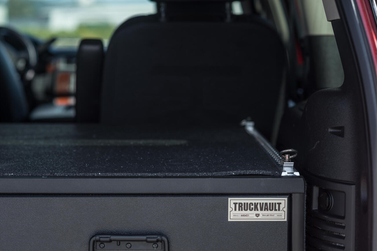 Rubber mat and tie down rail shown on top of a TruckVault secure storage drawer system