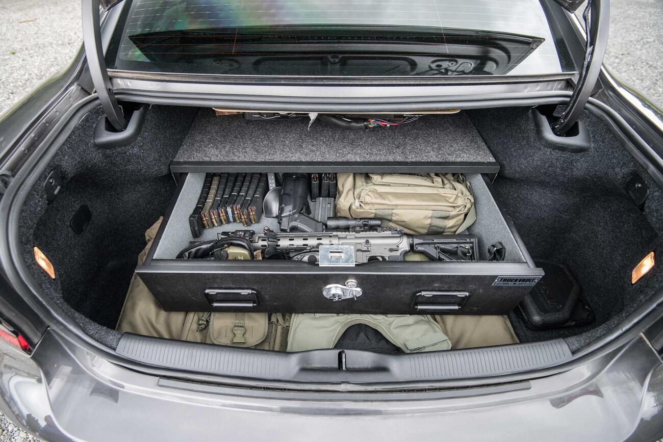 A Dodge Charger with an elevated TruckVault in the cargo space. The TruckVault is full of a gun and ammunition.