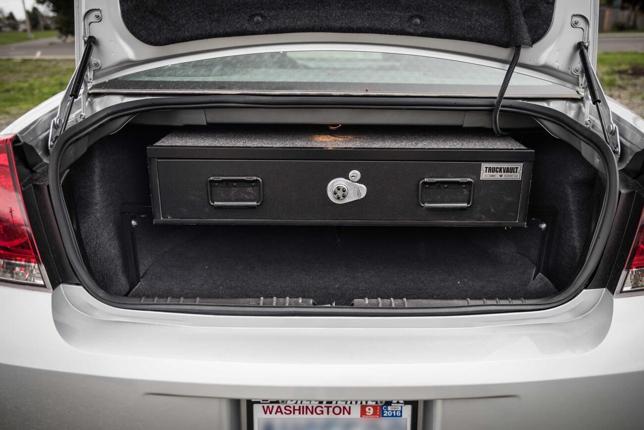 A silver Chevy Impala with an Elevated TruckVault in the trunk space.