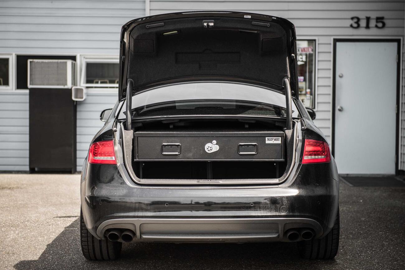 A gray Audi sedan with an elevated TruckVault in the cargo area.
