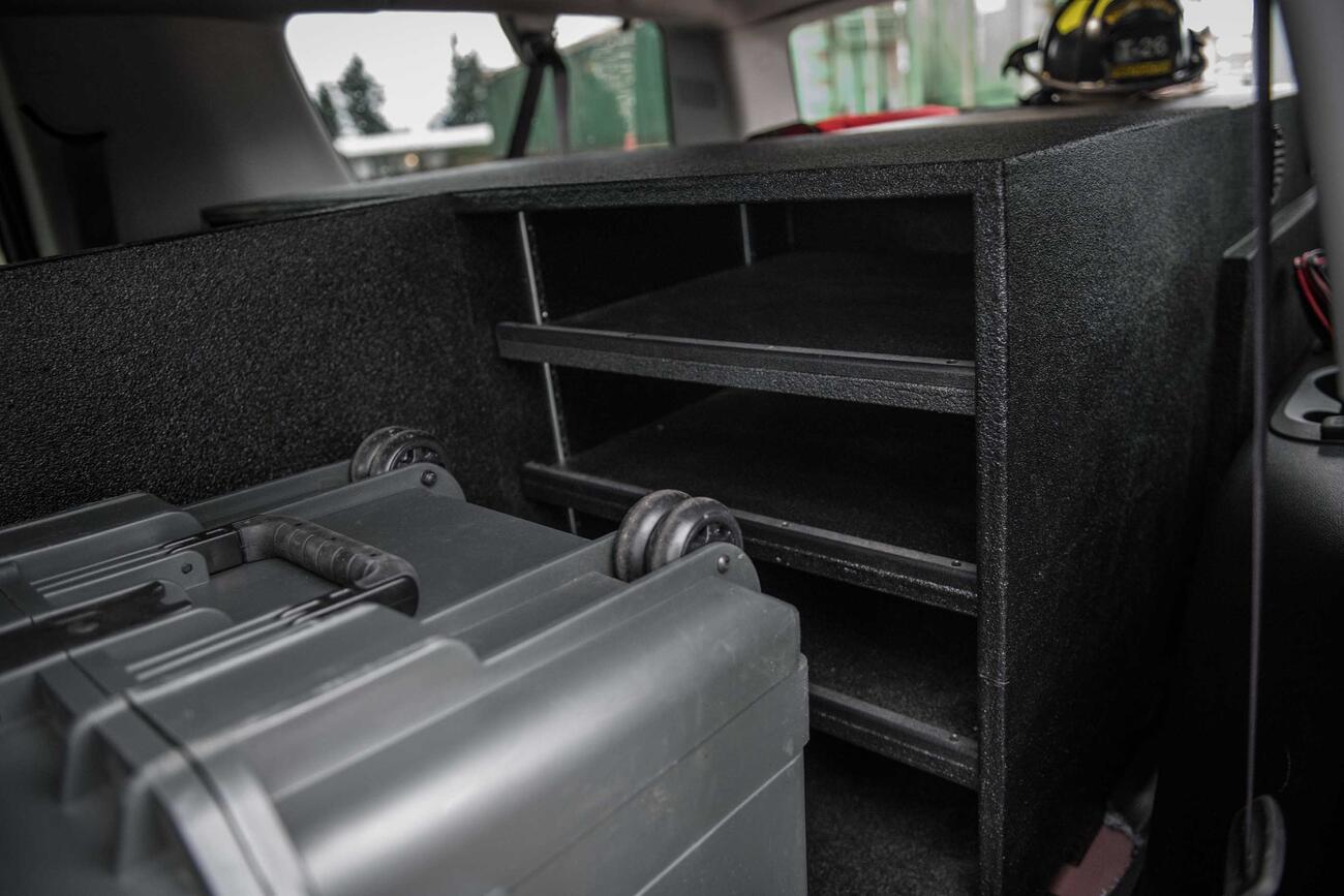 The inside of a fire department Chevy Suburban with a custom TruckVault and Pelican case.