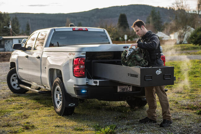 Law enforcement officer loading his TruckVault in a Chevy Silverado