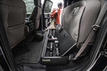 man reaches for camera gear in SeatVault by TruckVault