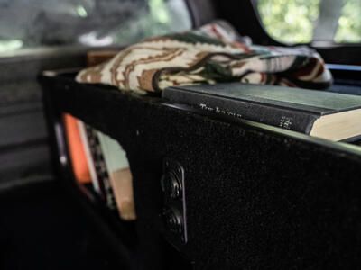books and blanket in drawer of TruckVault secure truck bed storage for camping and overlanding