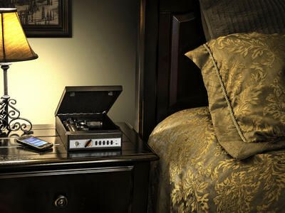 Shotlock with hand gun open on top of night stand with lit lamp