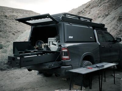 covered pickup truck with TruckVault secure storage drawer extended with fishing gear and camp kitchen inside