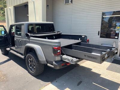 A Jeep Gladiator with a TruckVault storage system with the drawers pulled out.