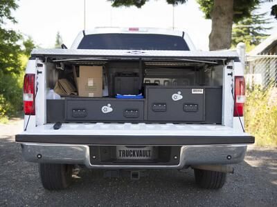 A White Ford F-150 with a covered bed and offset TruckVault drawers.