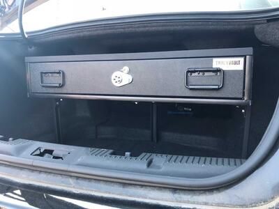 Open trunk of Ford Taurus with Elevated TruckVault secure storage system for sedans