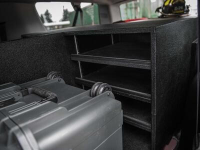 The inside of a fire department Chevy Suburban with a custom TruckVault and Pelican case.