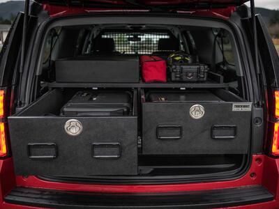 Two open TruckVault drawers in the back of a red Chevy Suburban. 
